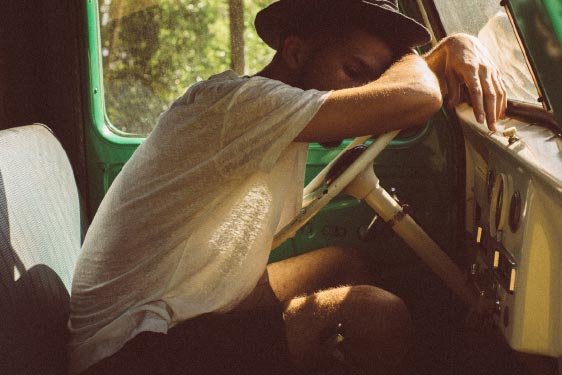 Man Laying with Arms on Steering Wheel
